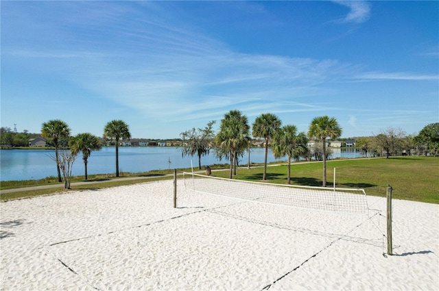 surrounding community with a water view and volleyball court