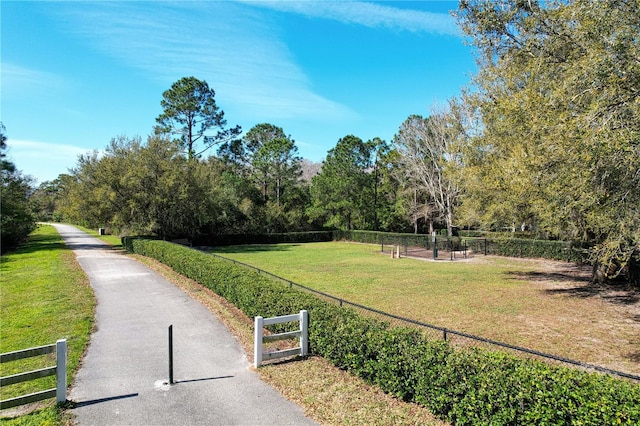 view of property's community featuring a yard and fence