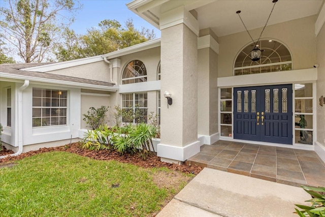 property entrance featuring roof with shingles and stucco siding