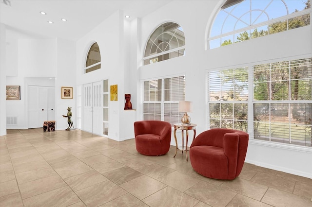 interior space with recessed lighting, visible vents, and a high ceiling