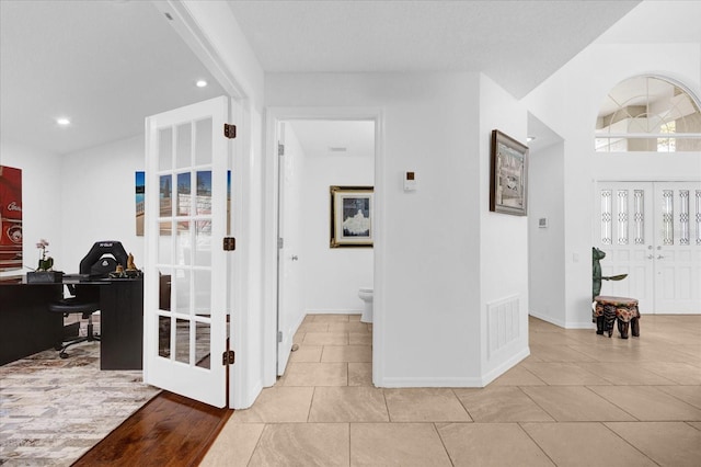 hallway with light tile patterned floors, baseboards, visible vents, and recessed lighting