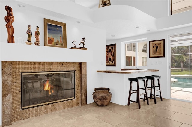 living room featuring a tiled fireplace and recessed lighting