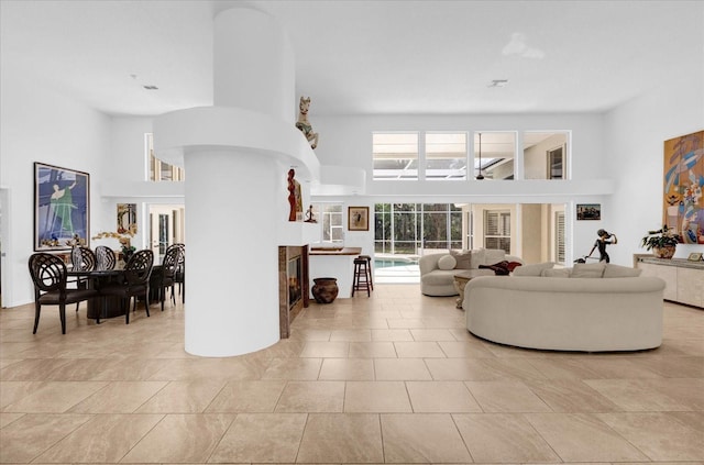 living area with a high ceiling and light tile patterned floors