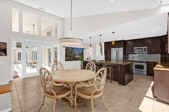 dining area with recessed lighting, french doors, visible vents, and a towering ceiling