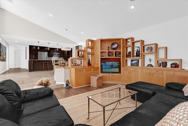 living room featuring light wood-style floors, high vaulted ceiling, and recessed lighting