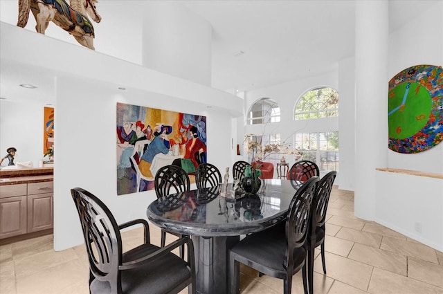 dining area featuring a high ceiling and light tile patterned flooring