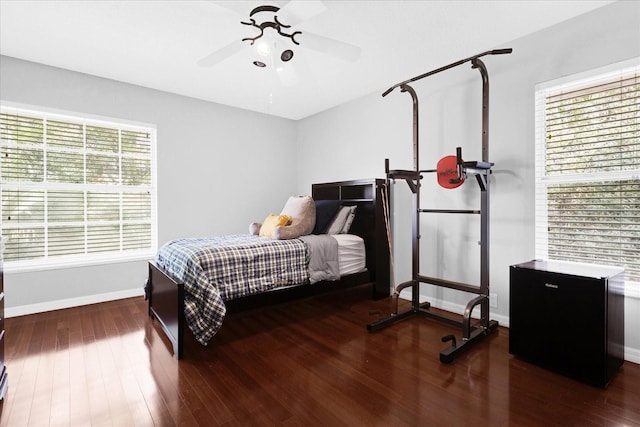 bedroom with ceiling fan, baseboards, and wood finished floors