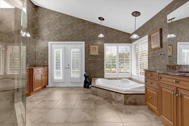 full bath featuring a garden tub, lofted ceiling, two vanities, a stall shower, and tile patterned flooring