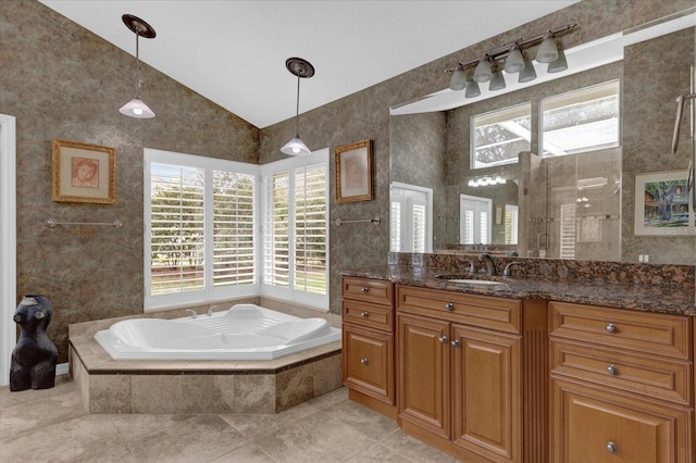 bathroom with a garden tub, vanity, vaulted ceiling, tiled shower, and tile patterned floors