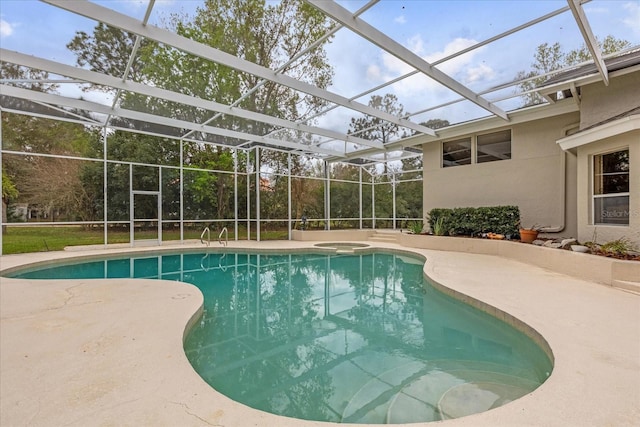 outdoor pool with glass enclosure, a patio area, and an in ground hot tub