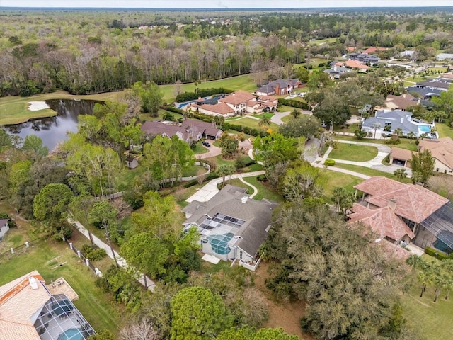 drone / aerial view featuring a residential view, a water view, and a view of trees