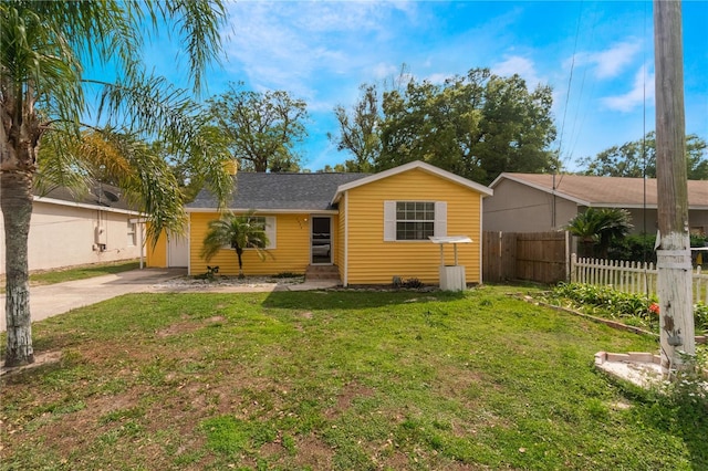 ranch-style house with a front yard, fence, and driveway