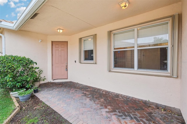 view of exterior entry with stucco siding