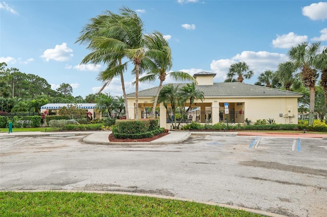 view of property featuring uncovered parking and fence