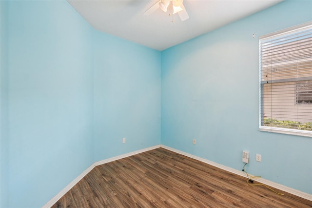 spare room with baseboards, wood finished floors, and a ceiling fan