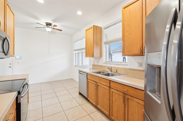 kitchen with light countertops, appliances with stainless steel finishes, light tile patterned flooring, a ceiling fan, and a sink