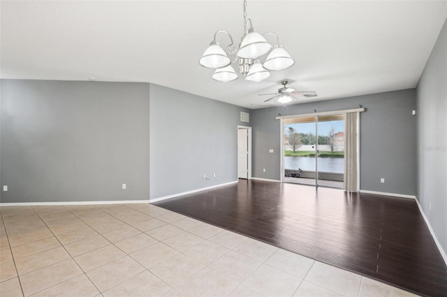 unfurnished room with wood finished floors, ceiling fan with notable chandelier, and baseboards