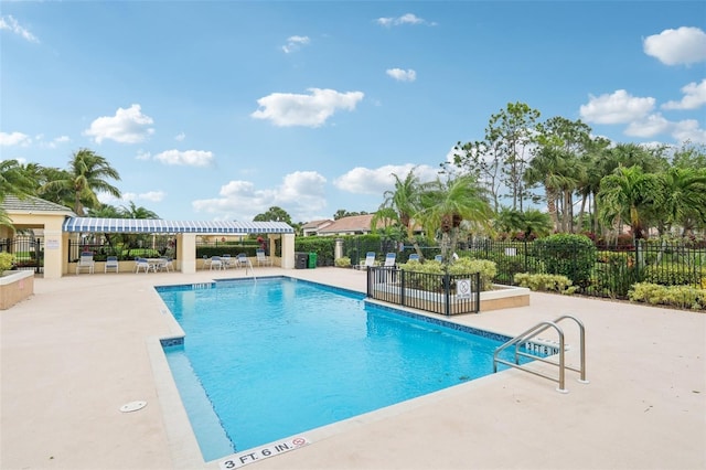 pool with a patio and fence