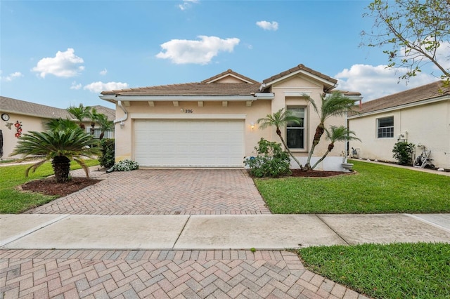 view of front facade featuring a front lawn, a tile roof, stucco siding, decorative driveway, and a garage