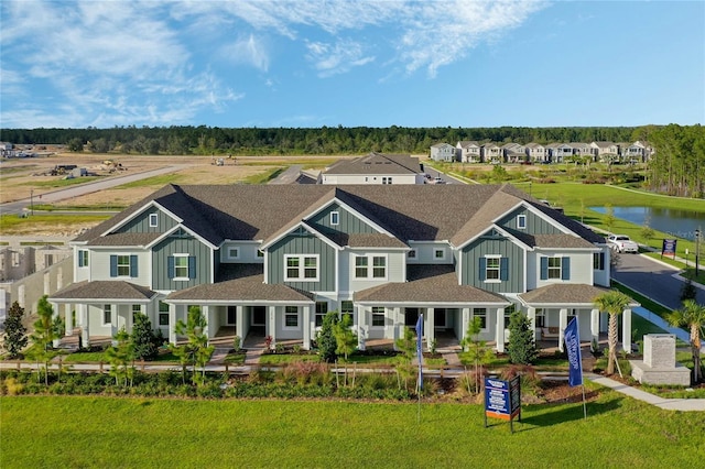 view of front of home with covered porch, a water view, a residential view, board and batten siding, and a front yard