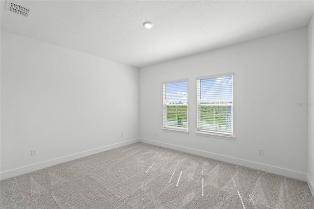 spare room with visible vents, baseboards, and light colored carpet