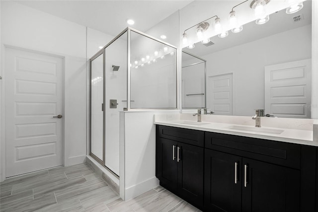 bathroom with visible vents, a sink, and a shower stall