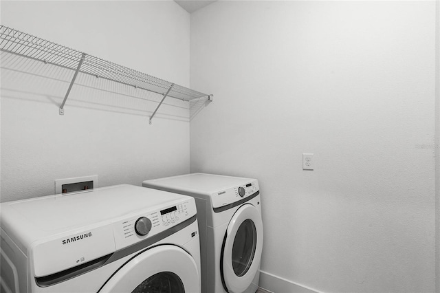 clothes washing area featuring laundry area, baseboards, and independent washer and dryer