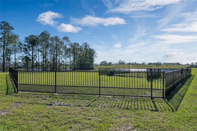 view of gate featuring a yard, a rural view, and fence