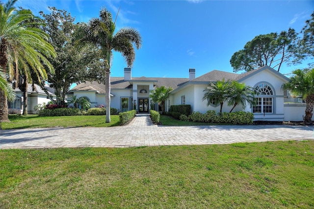 view of front of home with french doors, a front lawn, and stucco siding