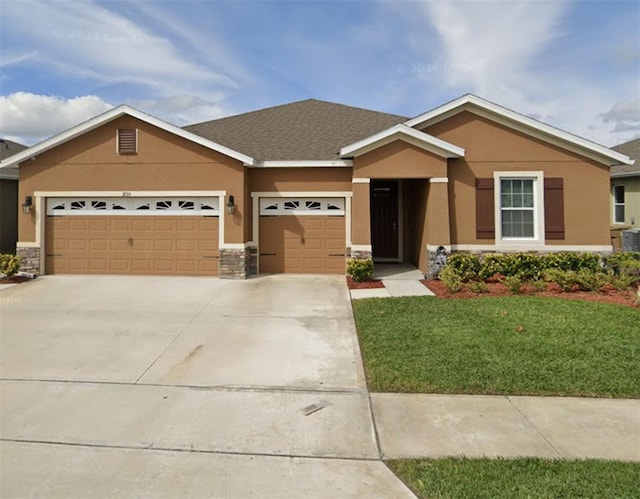 view of front facade with an attached garage, driveway, a front yard, and stucco siding