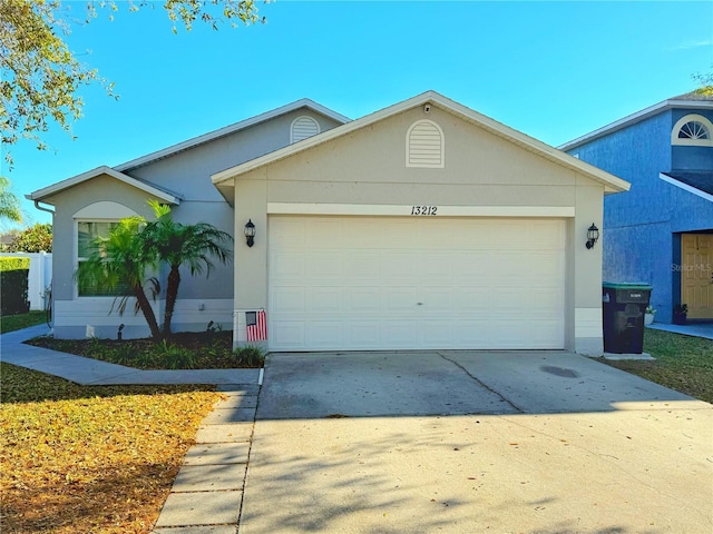 ranch-style home with a garage, driveway, and stucco siding