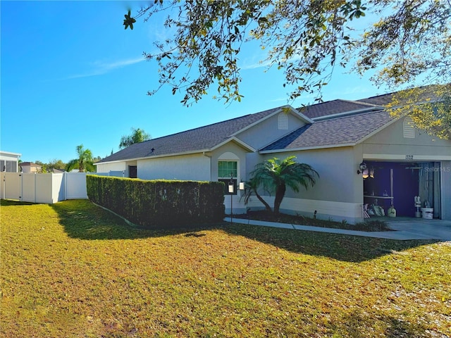 view of front of home featuring an attached garage, a shingled roof, fence, concrete driveway, and a front lawn