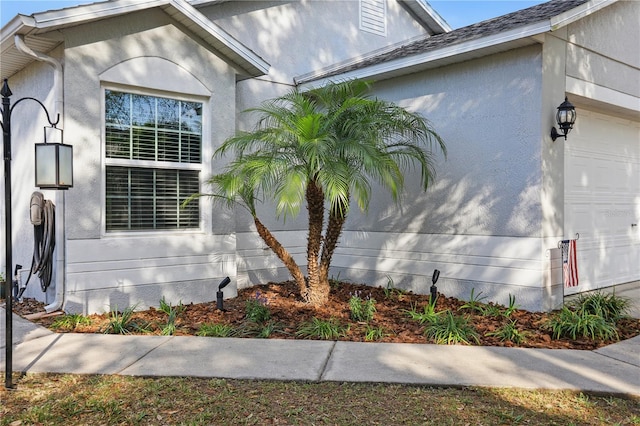 view of property exterior with stucco siding and an attached garage