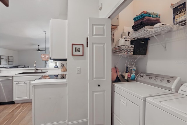 washroom featuring a sink, light wood-type flooring, laundry area, a ceiling fan, and separate washer and dryer