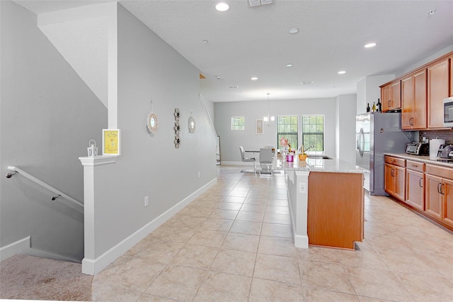 kitchen featuring stainless steel appliances, light tile patterned flooring, a center island with sink, and a sink