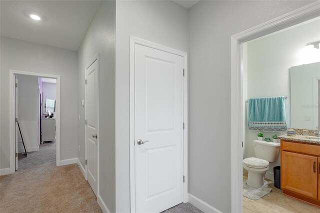 bathroom with baseboards, vanity, and toilet