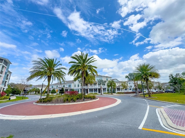 view of street featuring a residential view, curbs, sidewalks, and street lights