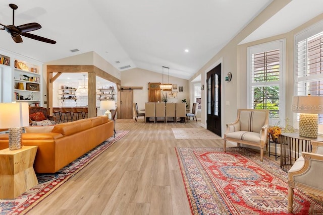 living room featuring visible vents, wood finished floors, ceiling fan, and vaulted ceiling