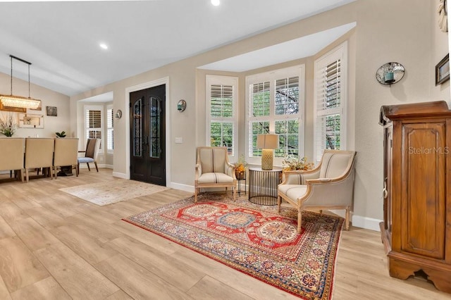 living area featuring vaulted ceiling, recessed lighting, light wood-style floors, and baseboards