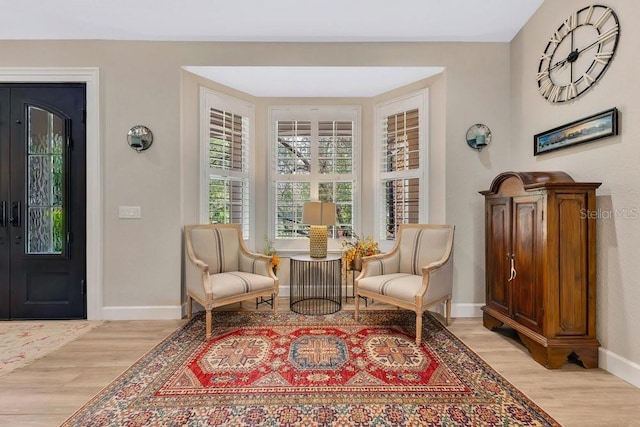 sitting room featuring baseboards and light wood finished floors