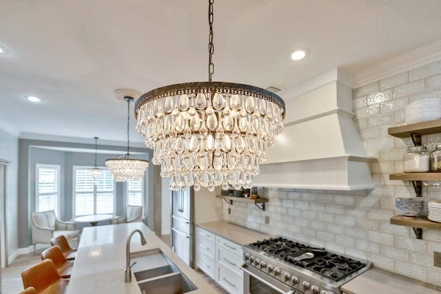 kitchen with a notable chandelier, stainless steel range, a sink, open shelves, and tasteful backsplash