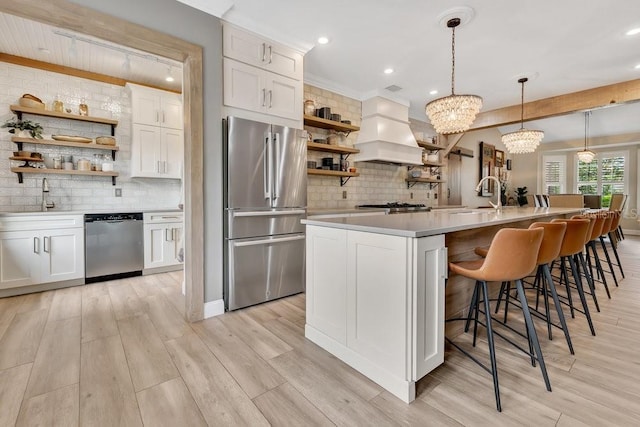 kitchen featuring a sink, open shelves, custom range hood, and stainless steel appliances