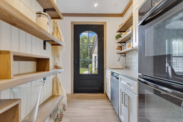 doorway to outside featuring light wood-type flooring and a sink