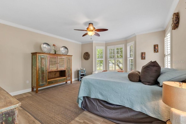 bedroom with crown molding, wood finished floors, baseboards, and ceiling fan