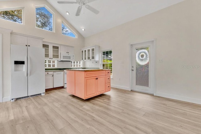 kitchen featuring glass insert cabinets, baseboards, light wood-style flooring, white appliances, and high vaulted ceiling