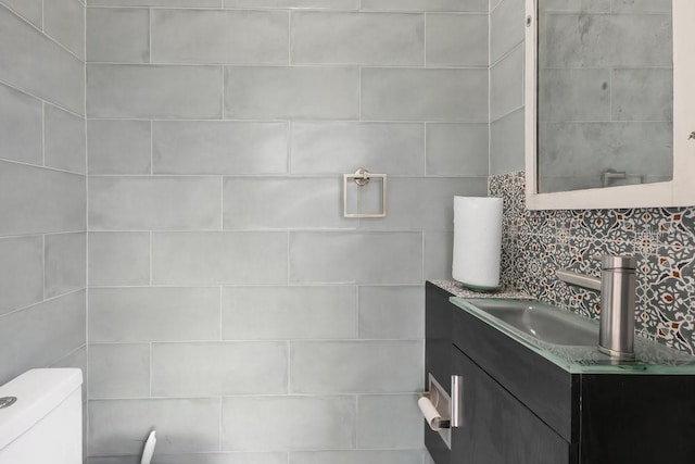 bathroom featuring tasteful backsplash, toilet, and vanity