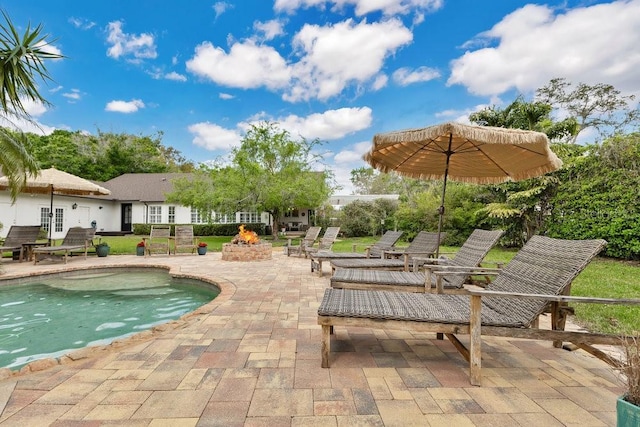 view of pool with a fire pit and a patio area