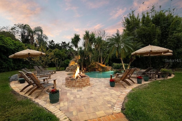 view of swimming pool featuring a yard, a patio, and an outdoor fire pit