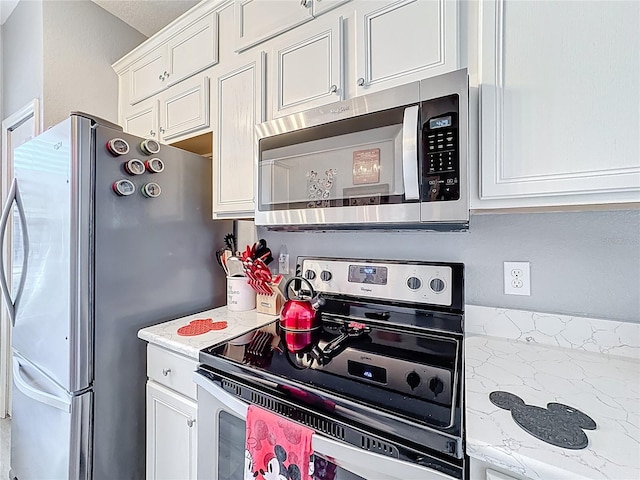 kitchen with light countertops, appliances with stainless steel finishes, and white cabinetry