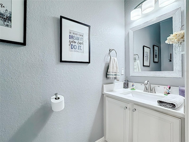 bathroom featuring a textured wall and vanity